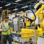 Un ouvrier face à un robot