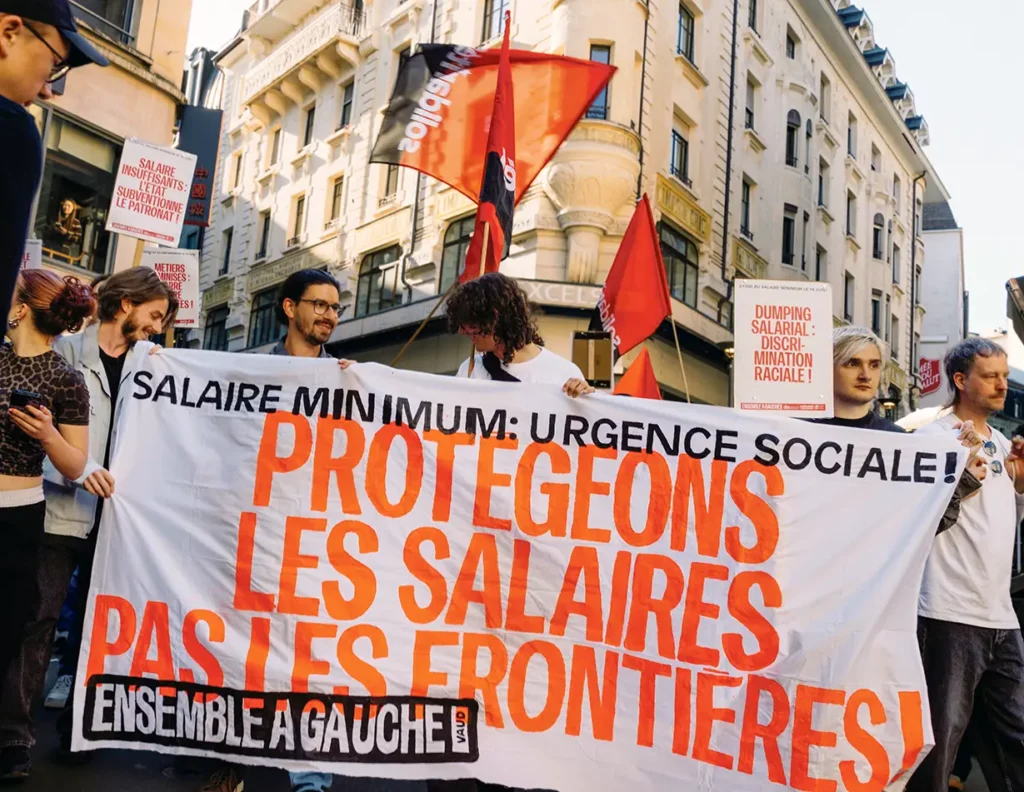 Banderole pour le salaire minimum et contre l'initiative UDC «pas de Suisse à 10 millions» lors du 1er Mai 2026 à Lausanne