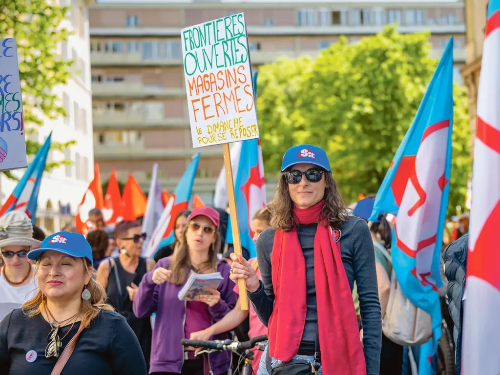 Pancarte “frontières ouvertes, magasins fermés le dimanche”, lors du cortège du 1er Mai 2026, Genève