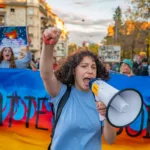 Une manifestante pour le climat devant une banderole avec des flammes