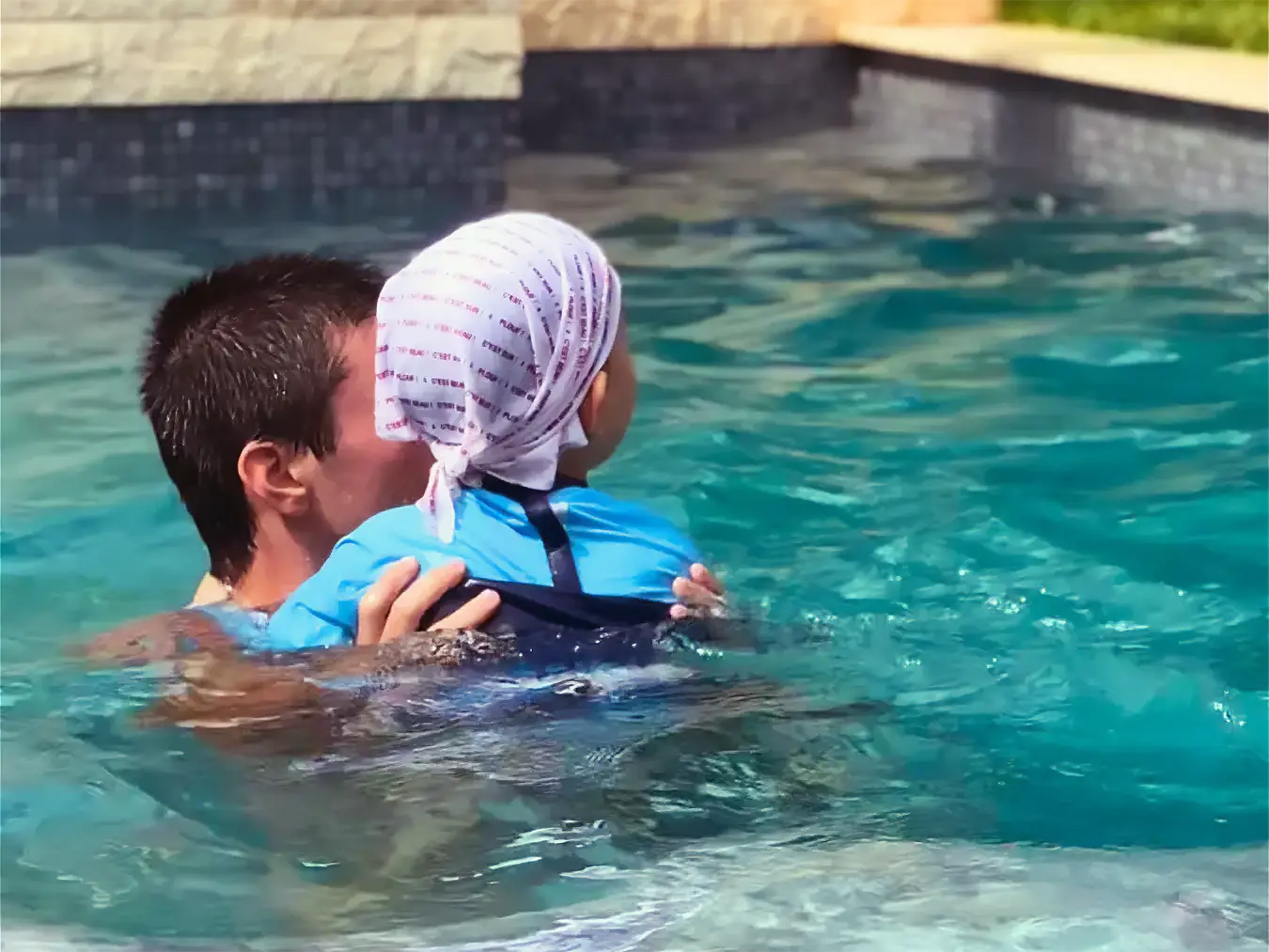 Un enfant avec portant des vêtements anti-UV dans une piscine