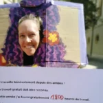 Une jeune femme tient une pancarte à propos du travail domestique